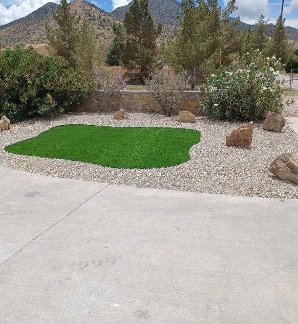 Artificial turf accent surrounded by gravel and accent boulders