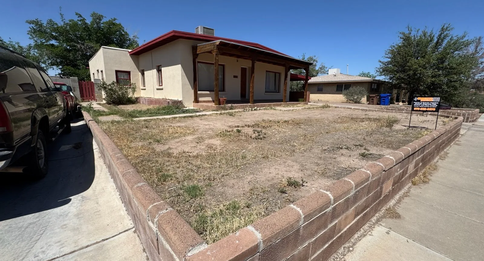 Before: bare front yard with weeds and patchy dirt inside the existing brick wall