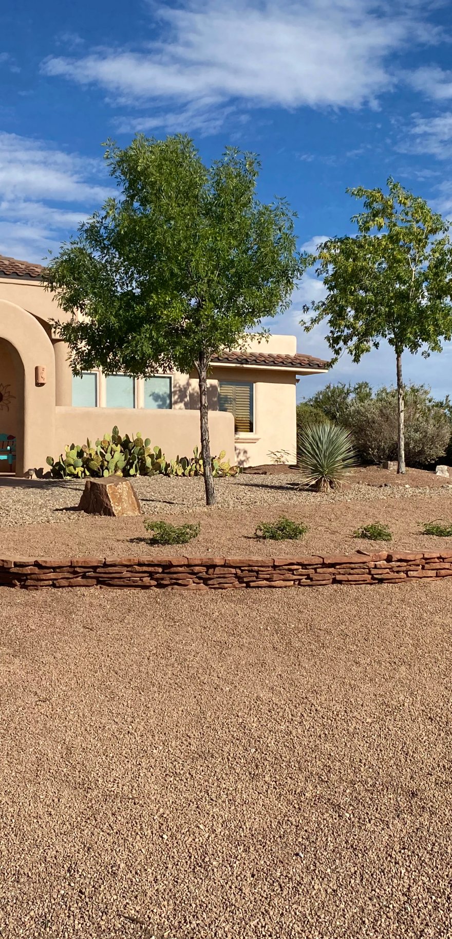 Stone border installation showing fieldstone and flagstone by Brainard's Greenscapes in Las Cruces, NM
