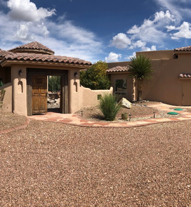 Panoramic view of a southwestern home with circular gravel xeriscape